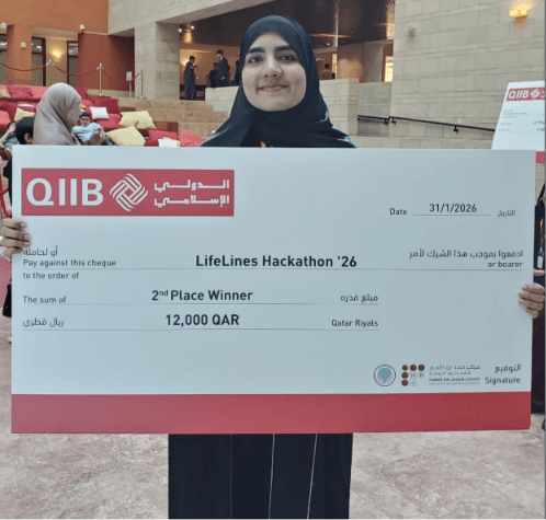 Ayesha holding the oversized 12,000 QAR second place cheque at the LifeLines Hackathon 2026